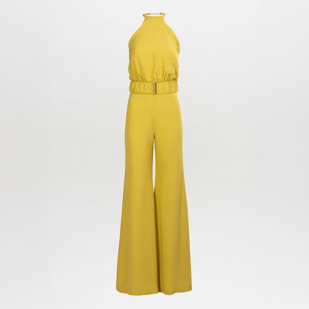 El mono Grosetto es una pieza amarilla sin mangas que presenta un escote halter, cintura ajustada y pantalones de pierna ancha, que se muestra sobre un fondo blanco liso.