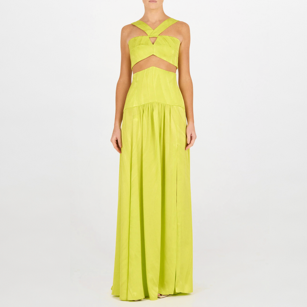 Una persona lleva el Falda Febe Verde Lime, un vestido verde lima sin mangas, largo hasta el suelo, con escote en la cintura y tirantes cruzados en el pecho. Un look de alta costura sobre fondo blanco liso.