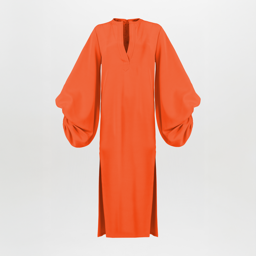 La Túnica Monferrato Orange es una túnica de crepé de color naranja vibrante, de largo hasta los tobillos, con mangas abullonadas, escote en V y aberturas laterales que irradia elegancia relajada sobre un fondo blanco liso.