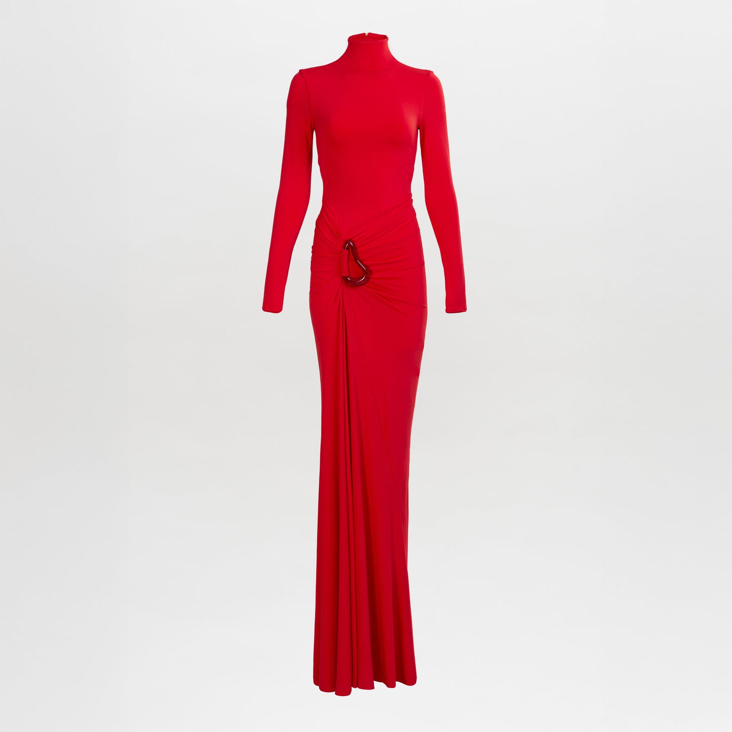 El vestido Lena es un vestido rojo de manga larga y largo hasta el suelo con escote alto, detalle fruncido en la cintura y un detalle metálico en un lateral. Está fotografiado sobre un fondo blanco liso.