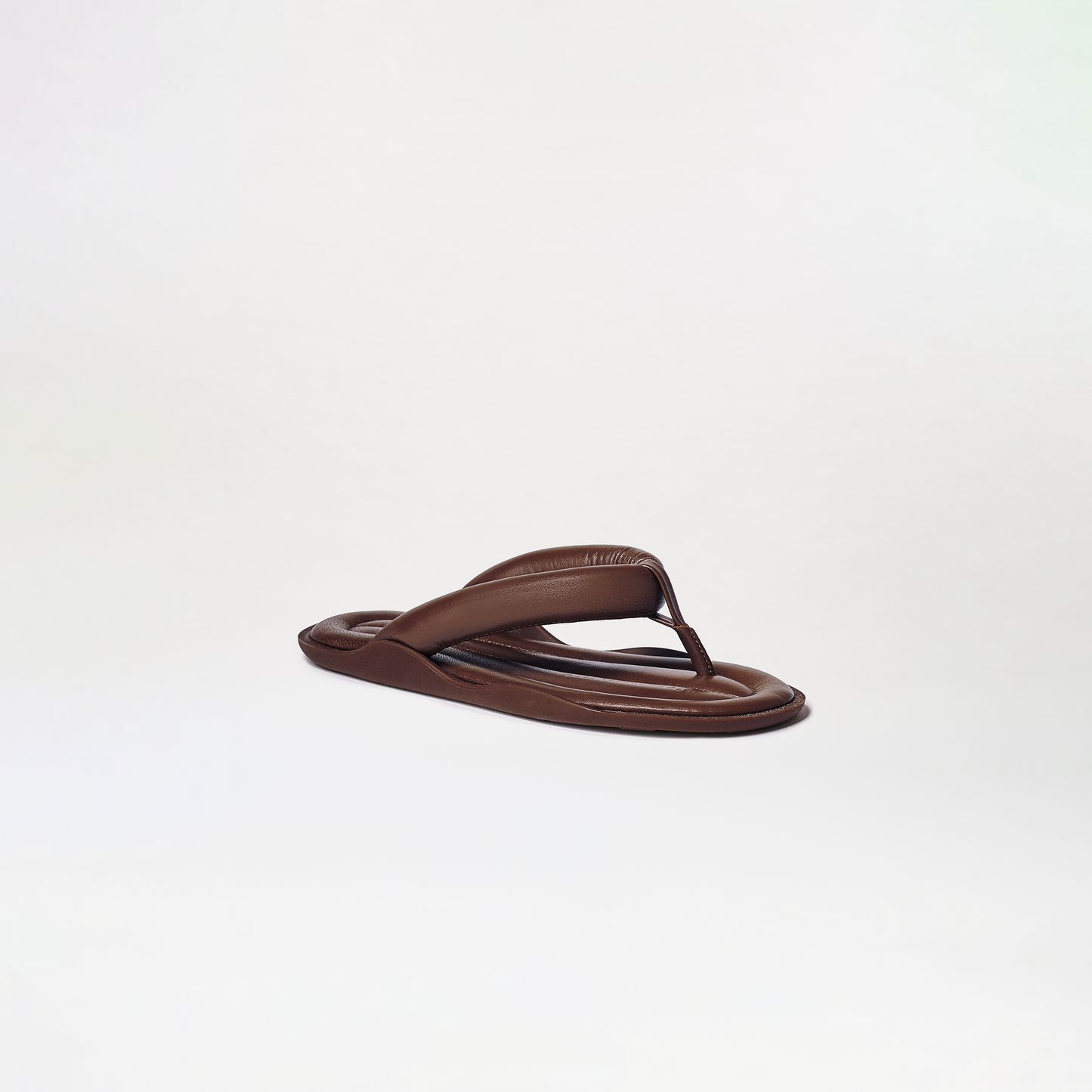 The Harper Sandals feature a single brown flip-flop with a padded thong strap and cushioned sole, showcased against a plain, light background.