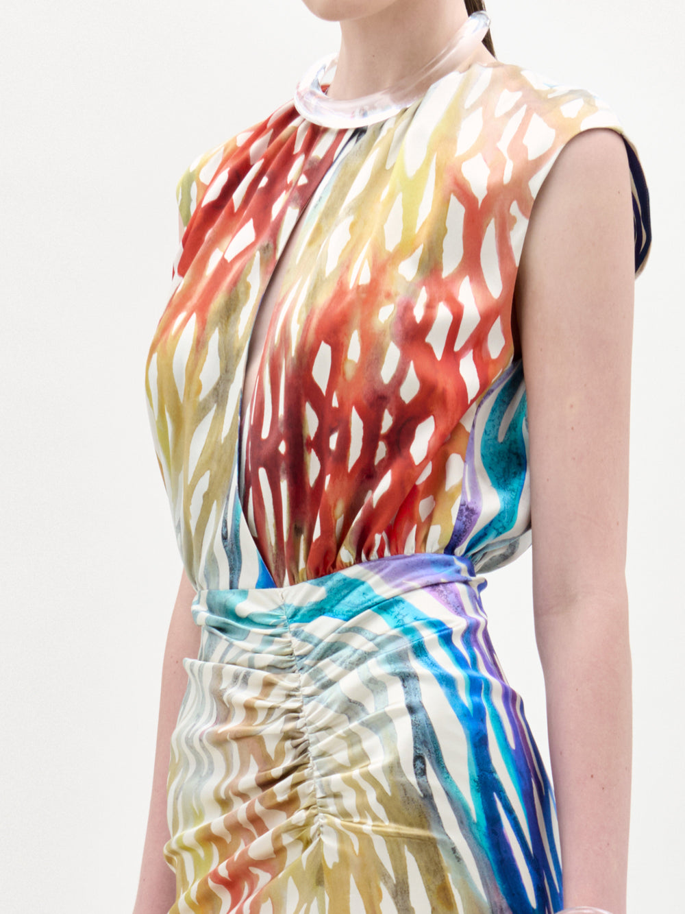 Una persona lleva el vestido Samaira, un maxi sin mangas con un colorido estampado abstracto en rojo, amarillo, azul y blanco. Tiene escote alto, cintura fruncida y está confeccionado en Colombia.