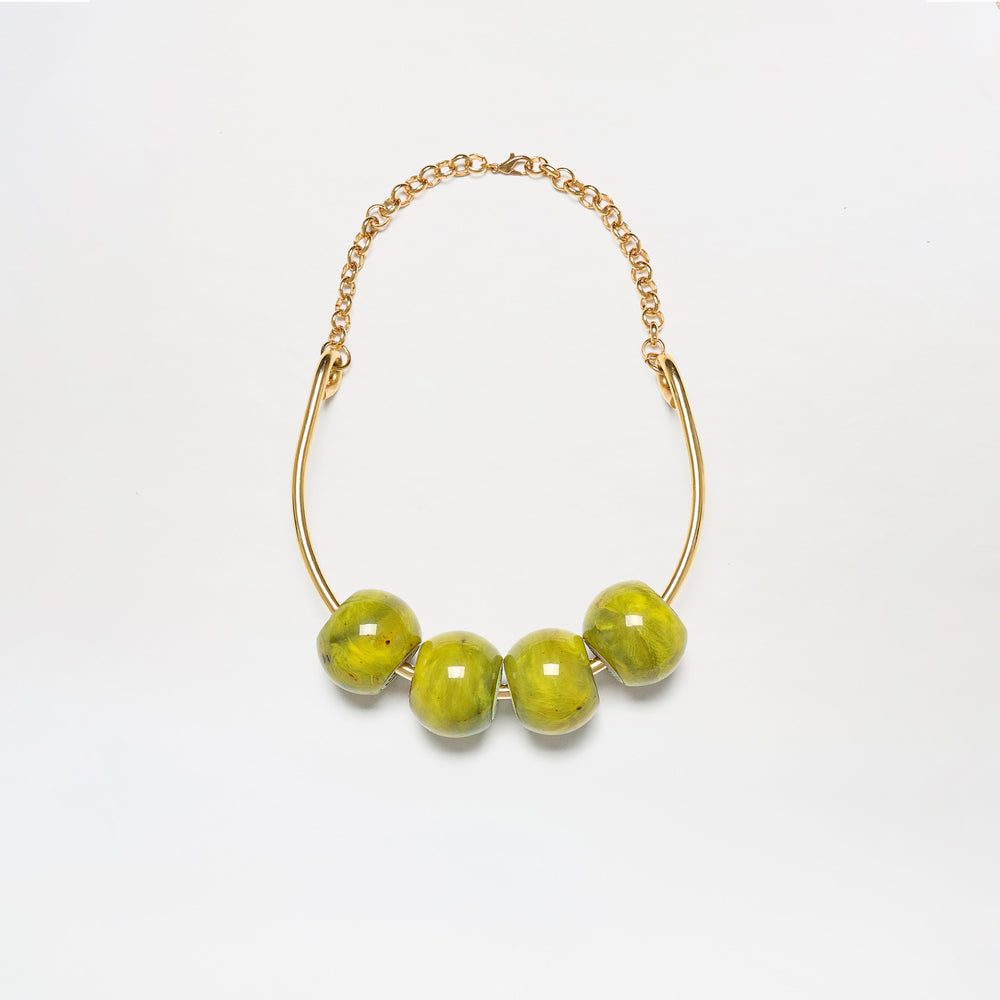 The Martini Chocker is a gold chain necklace featuring four large, glossy green beads on a curved gold bar, shown against a white background.