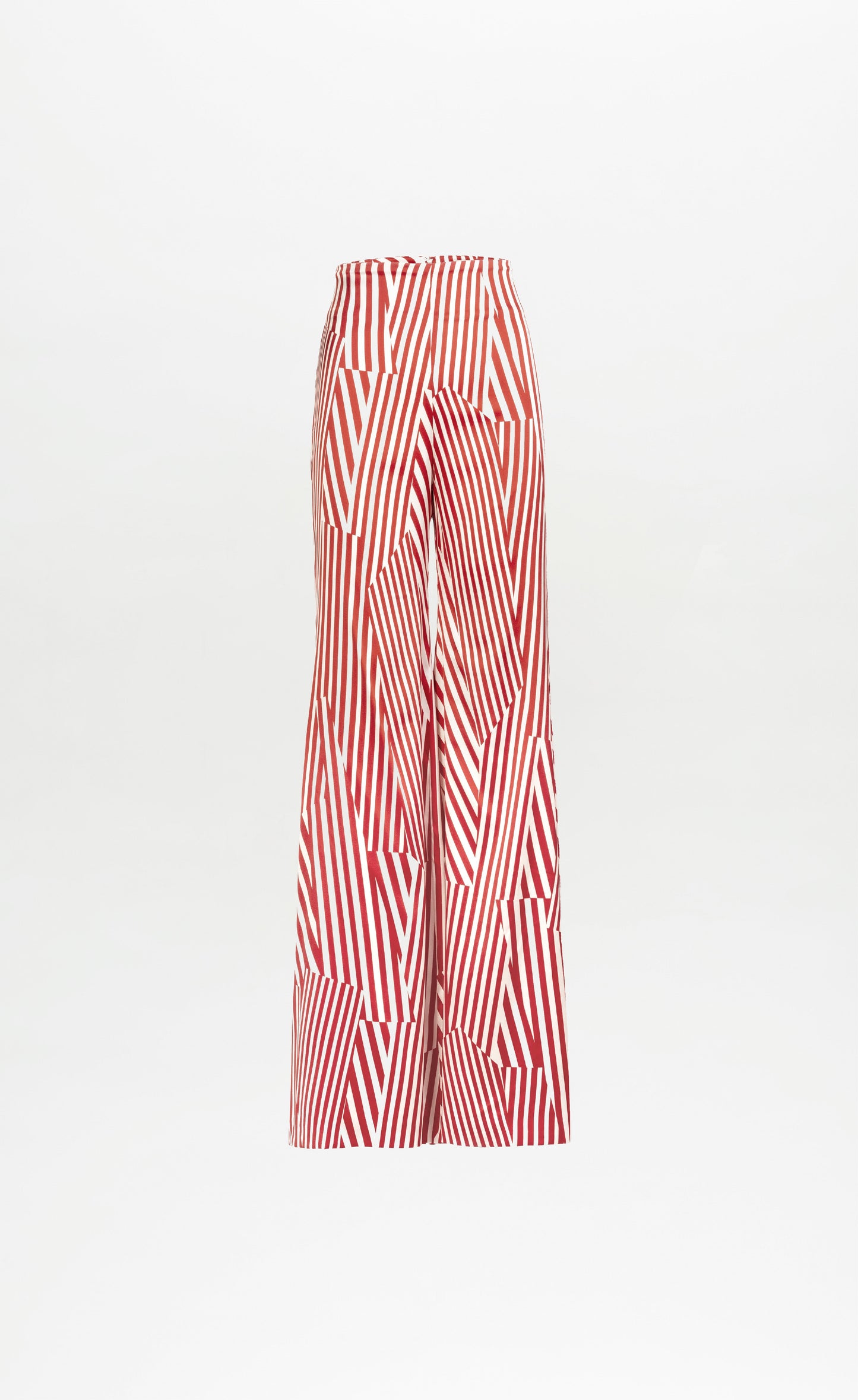 El pantalón Andie es un modelo de cintura alta y pernera ancha con un estampado geométrico en rojo y blanco de rayas verticales y diagonales sobre un fondo blanco liso.
