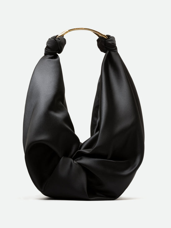 A Sofia Bag (Maxi) Black with a draped fabric design, featuring a metallic gold handle at the top, available for pre-order now and set to ship in early 2024.