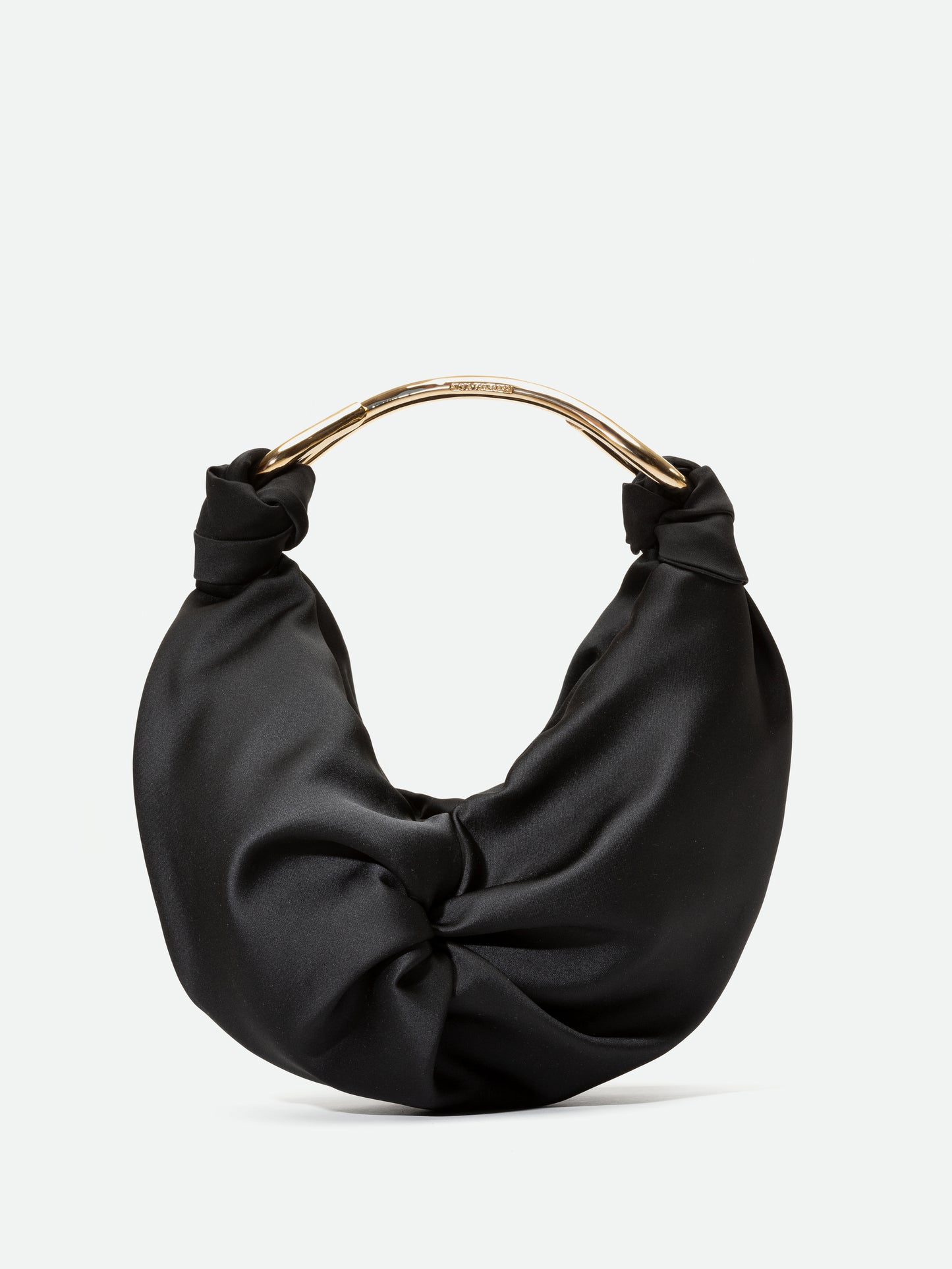 El Bolso Sofia Black (Small) es un bolso de tela negro con un aspecto fruncido y retorcido sobre un fondo liso. Cuenta con una elegante asa brillante en tono dorado que se enrolla con gracia sobre el bolso.