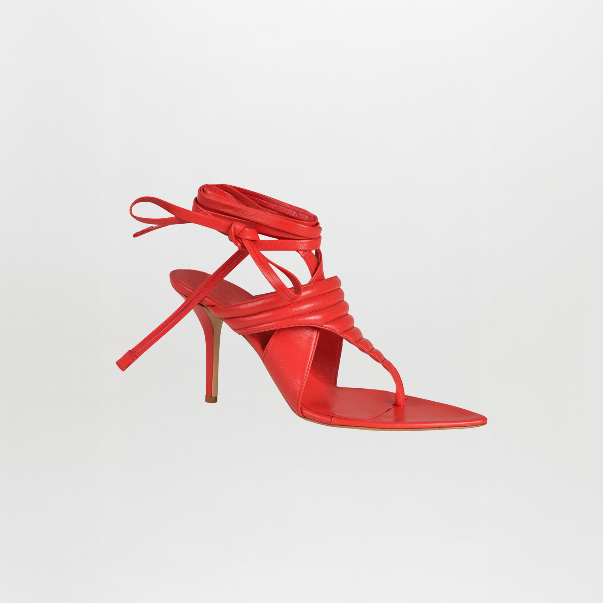 Tacones Dalila Rojos es una sandalia roja de tacón alto con tiras finas, punta cuadrada y cordones que rodean el tobillo, sobre un fondo blanco liso.