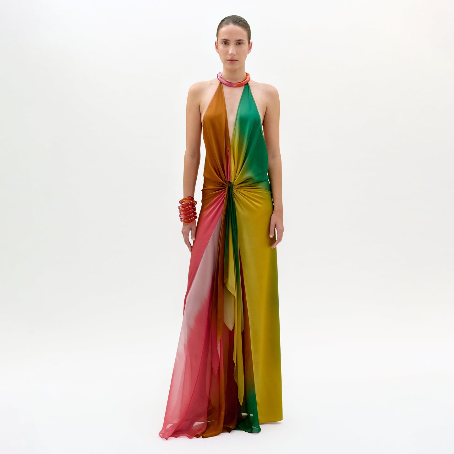 Lleva el vestido Dixon -un maxi sin mangas y largo hasta el suelo con escote halter en tonos rojos, amarillos, verdes y marrones mezclados- rematado con un detalle de nudo central, además de pulseras rojas y una gargantilla.