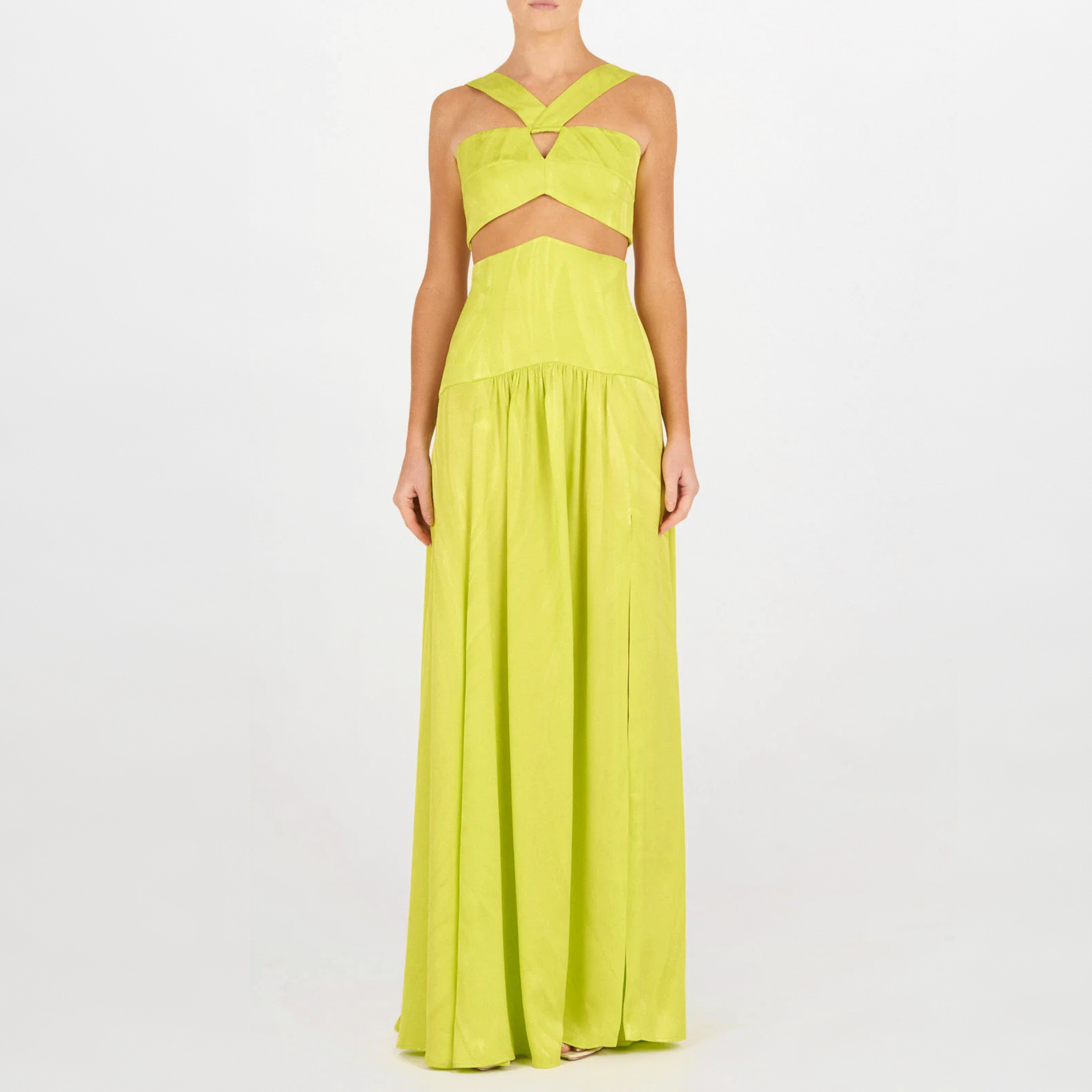 Una persona lleva el Falda Febe Verde Lime, un vestido verde lima sin mangas, largo hasta el suelo, con escote en la cintura y tirantes cruzados en el pecho. Un look de alta costura sobre fondo blanco liso.