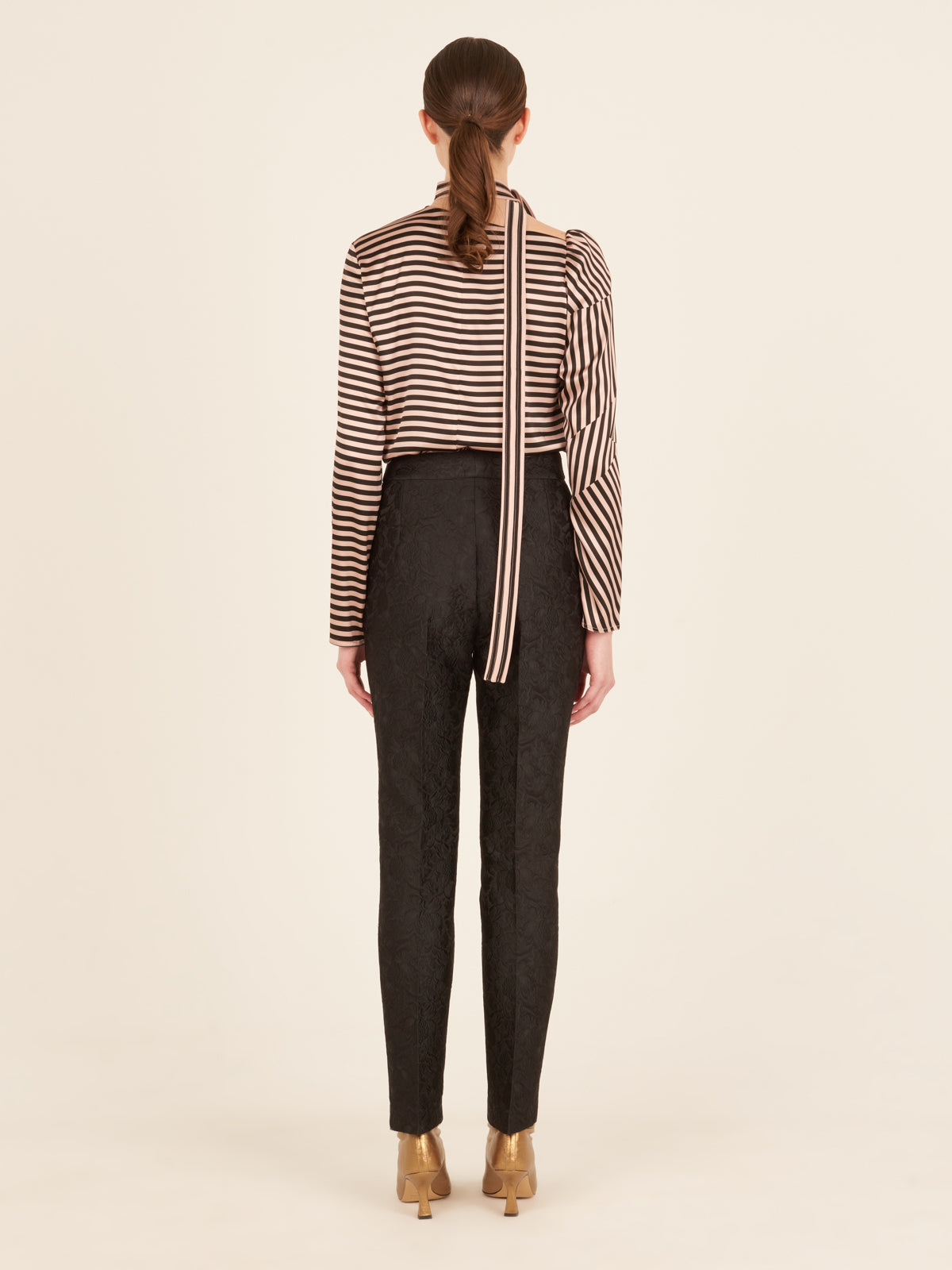 Orion Pant Black high-waisted pants with a patterned design and a gold detail on the waistband.