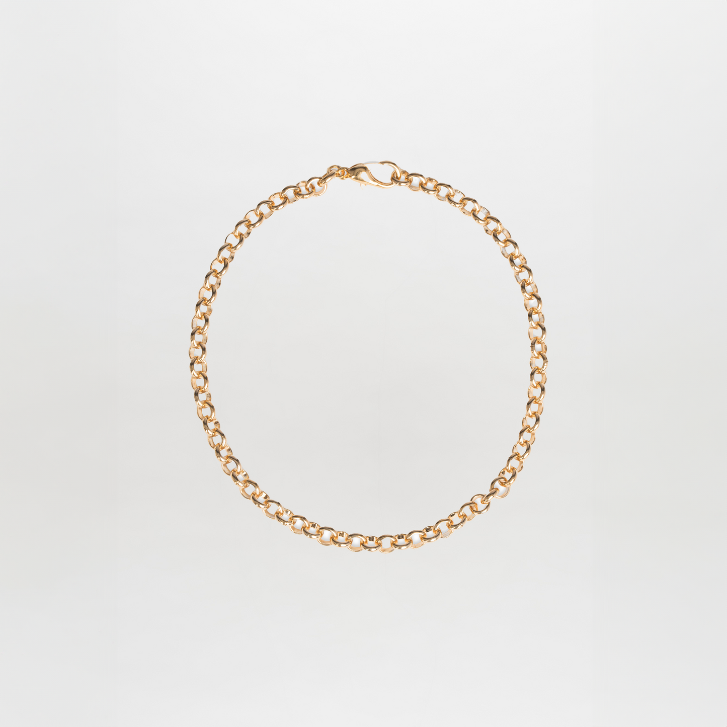El Collar Felisa Gold es una sencilla pulsera de cadena de oro con eslabones redondos y cierre de langosta, elaborada en latón bañado en oro y mostrada sobre un fondo blanco liso.