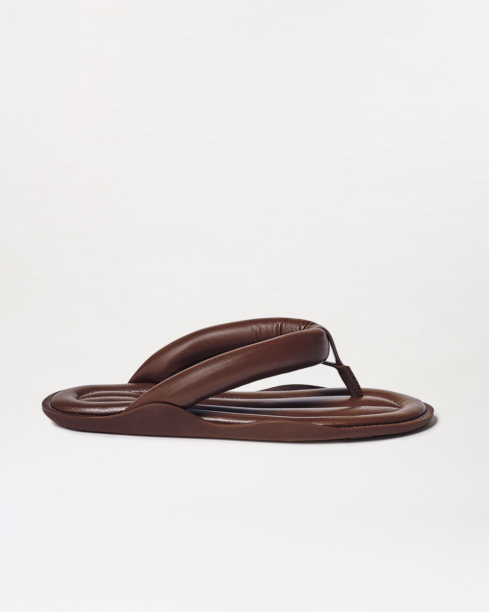 The Harper Sandals are brown padded flip-flops featuring thick, cushioned straps and a rounded sole, shown on a plain white background.