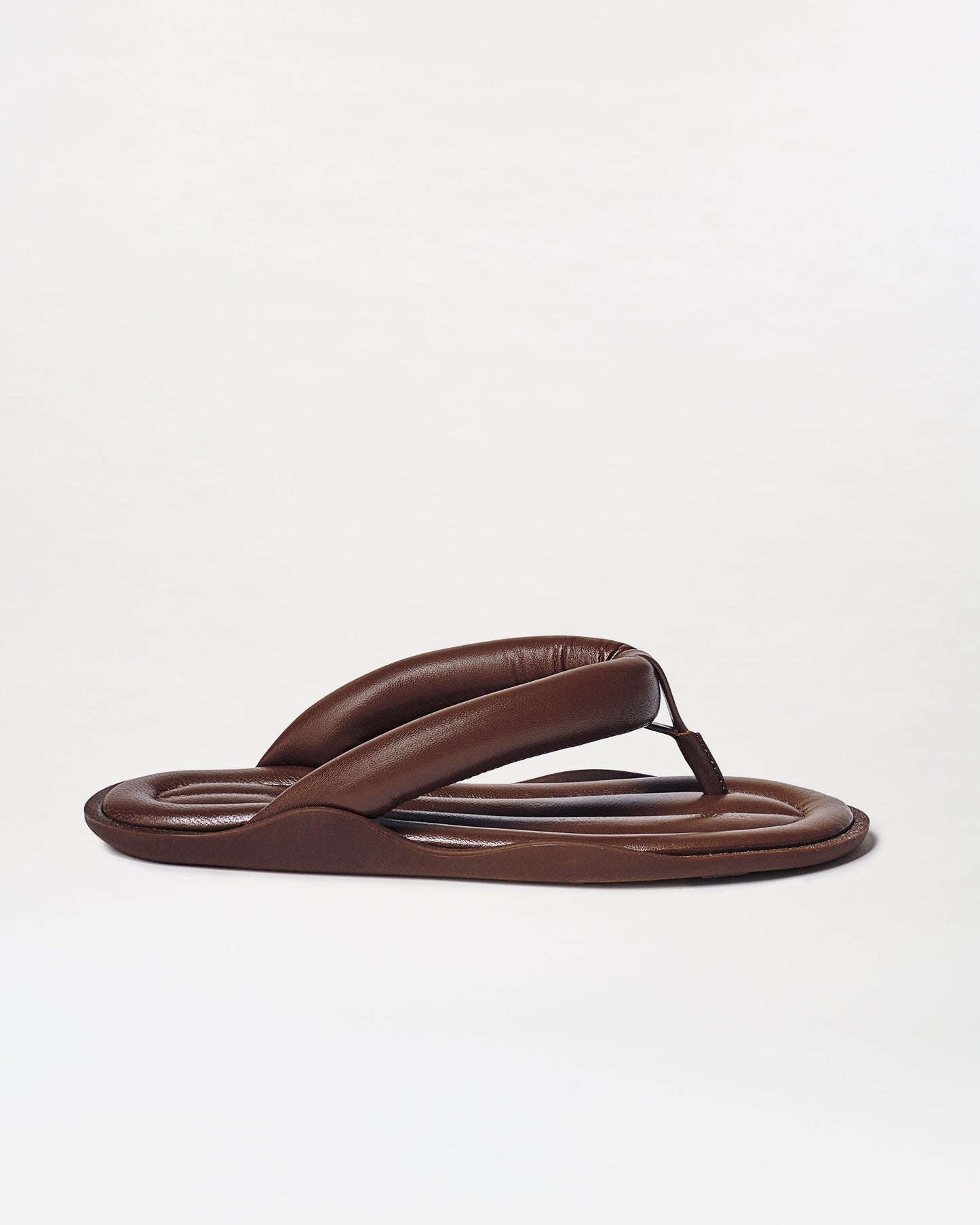 The Harper Sandals are brown padded flip-flops featuring thick, cushioned straps and a rounded sole, shown on a plain white background.
