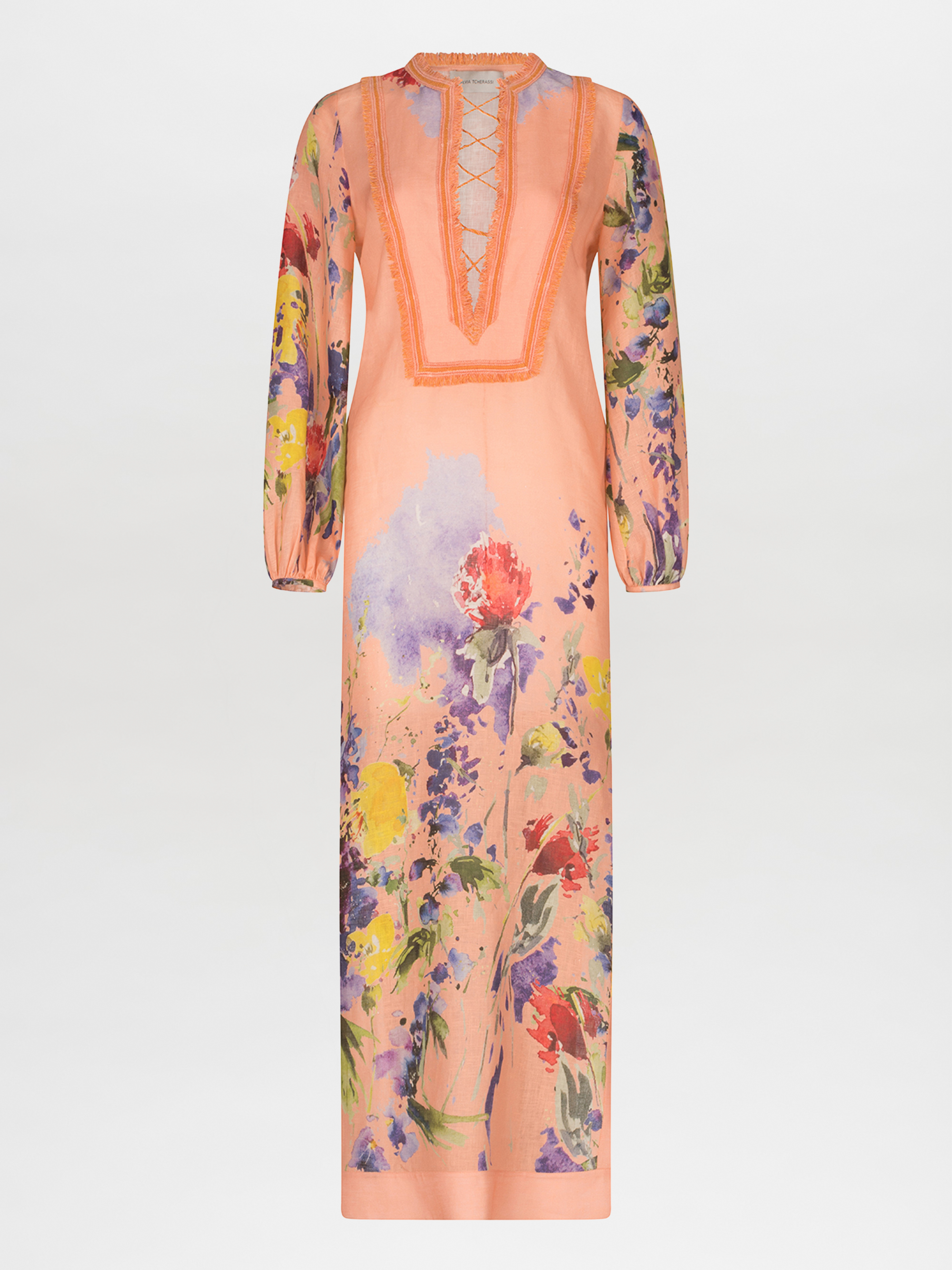 Túnica Isernia es un vestido largo de manga larga 100% lino que presenta un escote en V con cordones y un estampado floral en violeta, amarillo, verde y rojo, sobre un fondo blanco liso.