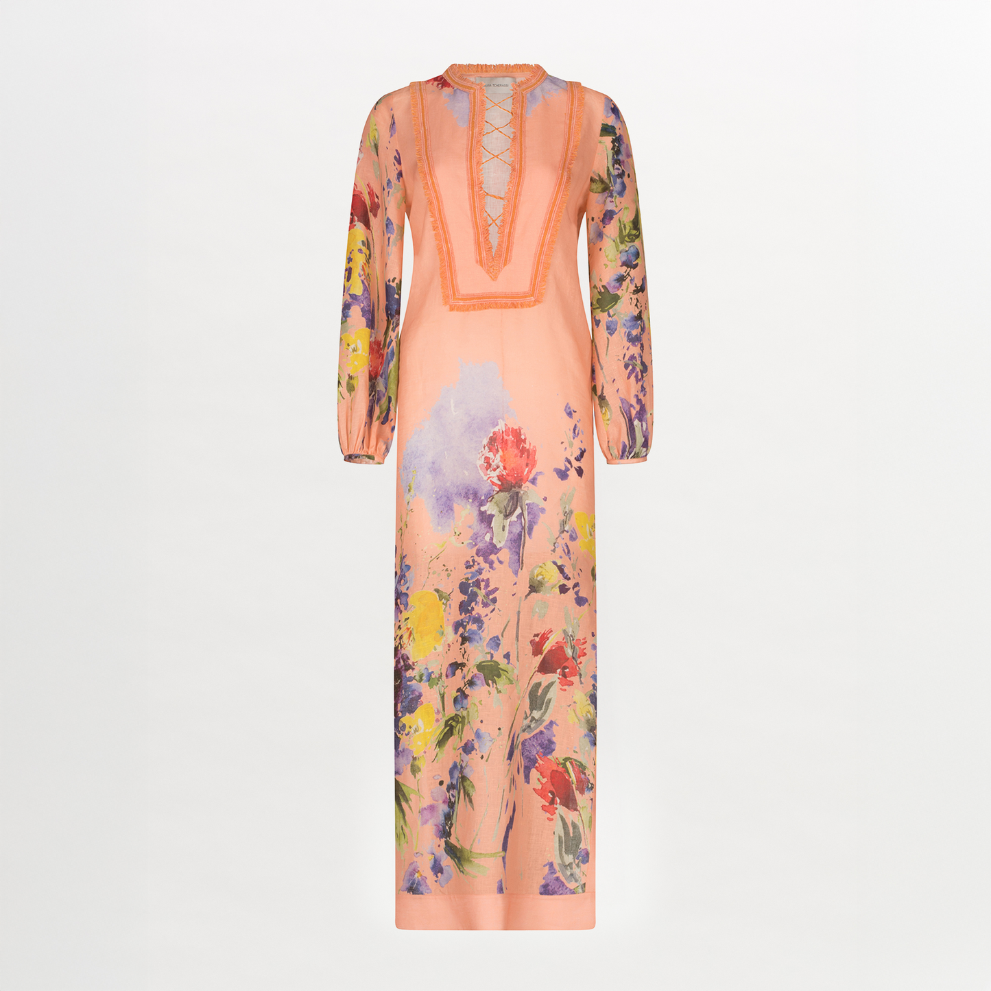 El Túnica Isernia es un maxivestido melocotón de manga larga y largo hasta los tobillos, con escote en pico con cordones y coloridos estampados florales en las mangas y el bajo. Esta prenda holgada y de silueta recta está hecha en Colombia.