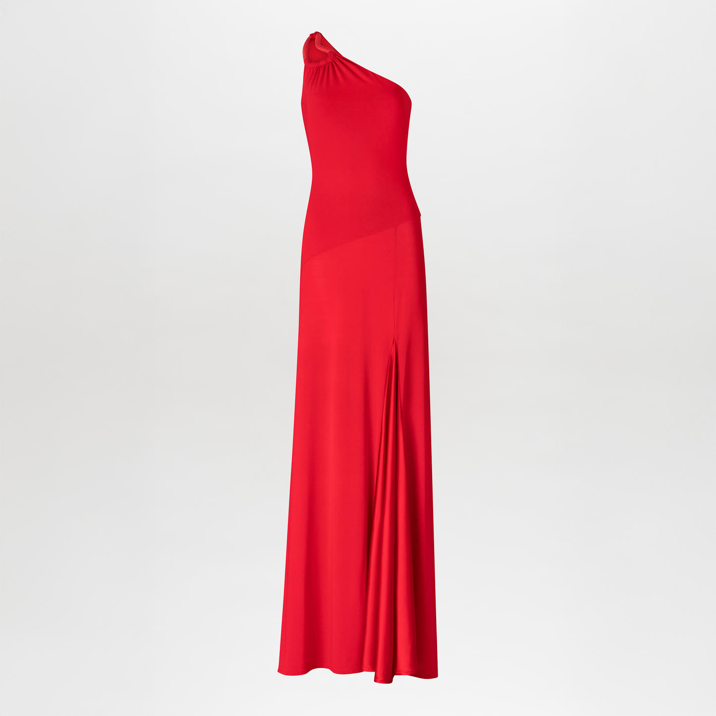 El Vestido Kanya es un maxivestido rojo largo con escote asimétrico y un solo hombro. Presenta un corpiño ajustado, hombros fruncidos y una falda ligeramente evasé de tela suave. Se presenta sobre un fondo blanco liso.