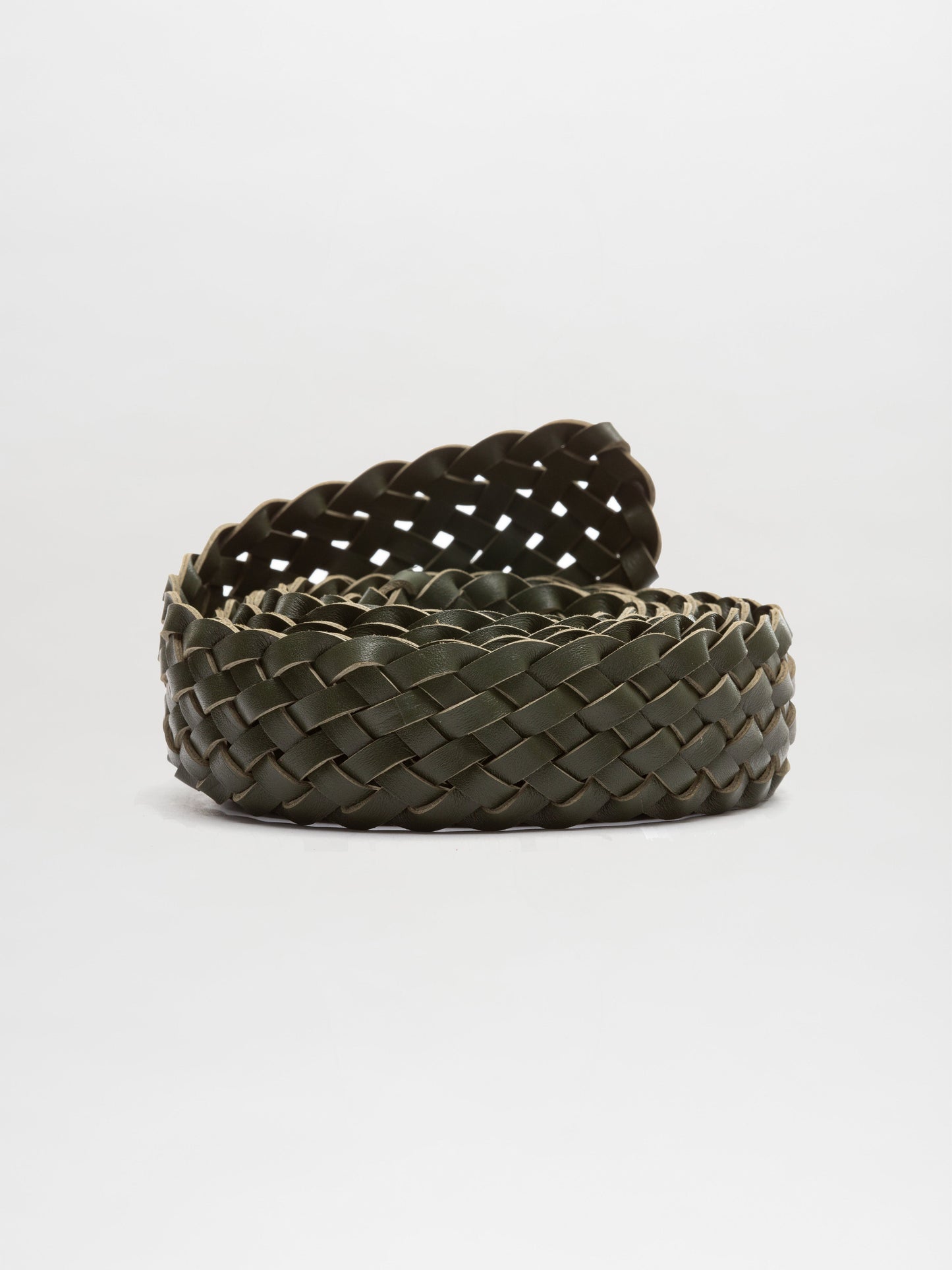 Cinturón Lauren, un cinturón tejido en espiral elaborado con cuero verde oscuro con patrón de tejido de canasta, hecho en Colombia, se exhibe sobre un fondo blanco liso.