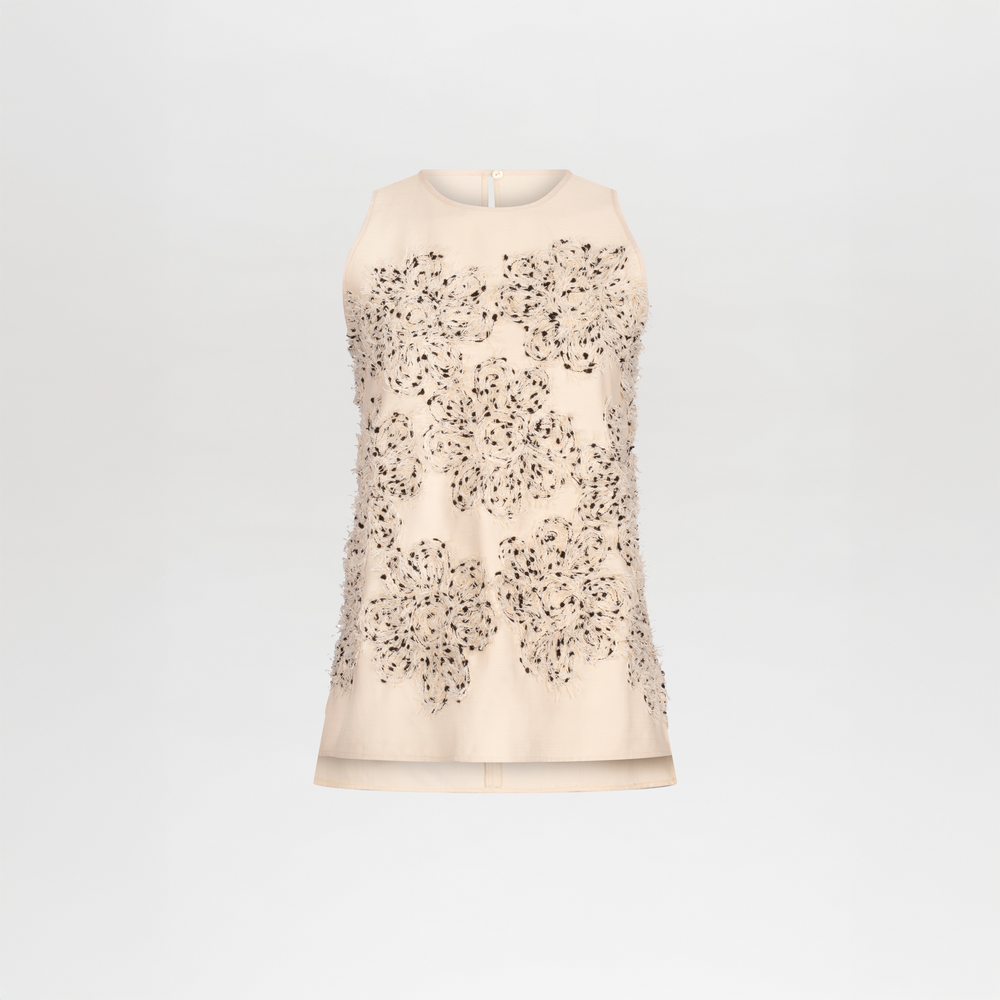 Blusa Leonora: Vestido mini sin mangas de color crema con escote cerrado, grandes detalles florales aplicados y pequeños detalles de cuentas en la parte delantera, sobre un fondo blanco liso.