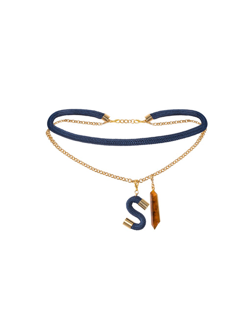 Mireya Belt Navy is the ideal choice for September 2nd, featuring a stylish blue cord and gold chain adorned with two elegant pendants: a gold-edged blue 'S' and a stunning gold and brown crystal.