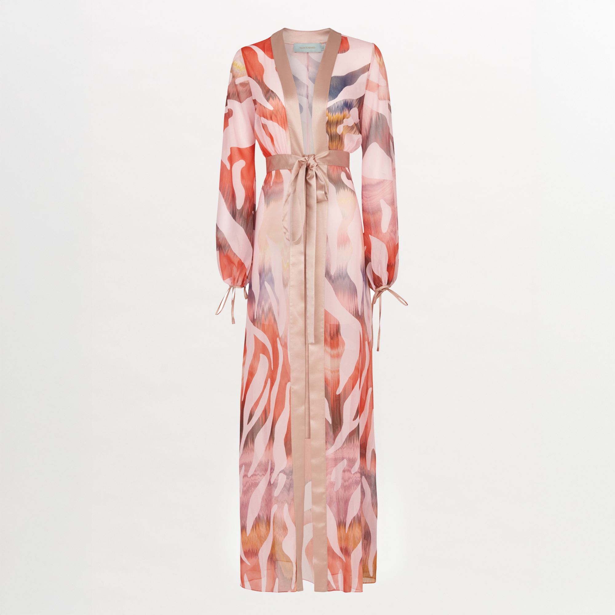 El Vestido Magdalena Blush Prismatic es una bata larga inspirada en Silvia Tcherassi, con un estampado abstracto de cebra en rosa, rojo y beige, cuello de pico, mangas con cordón y cinturón a juego sobre fondo blanco.