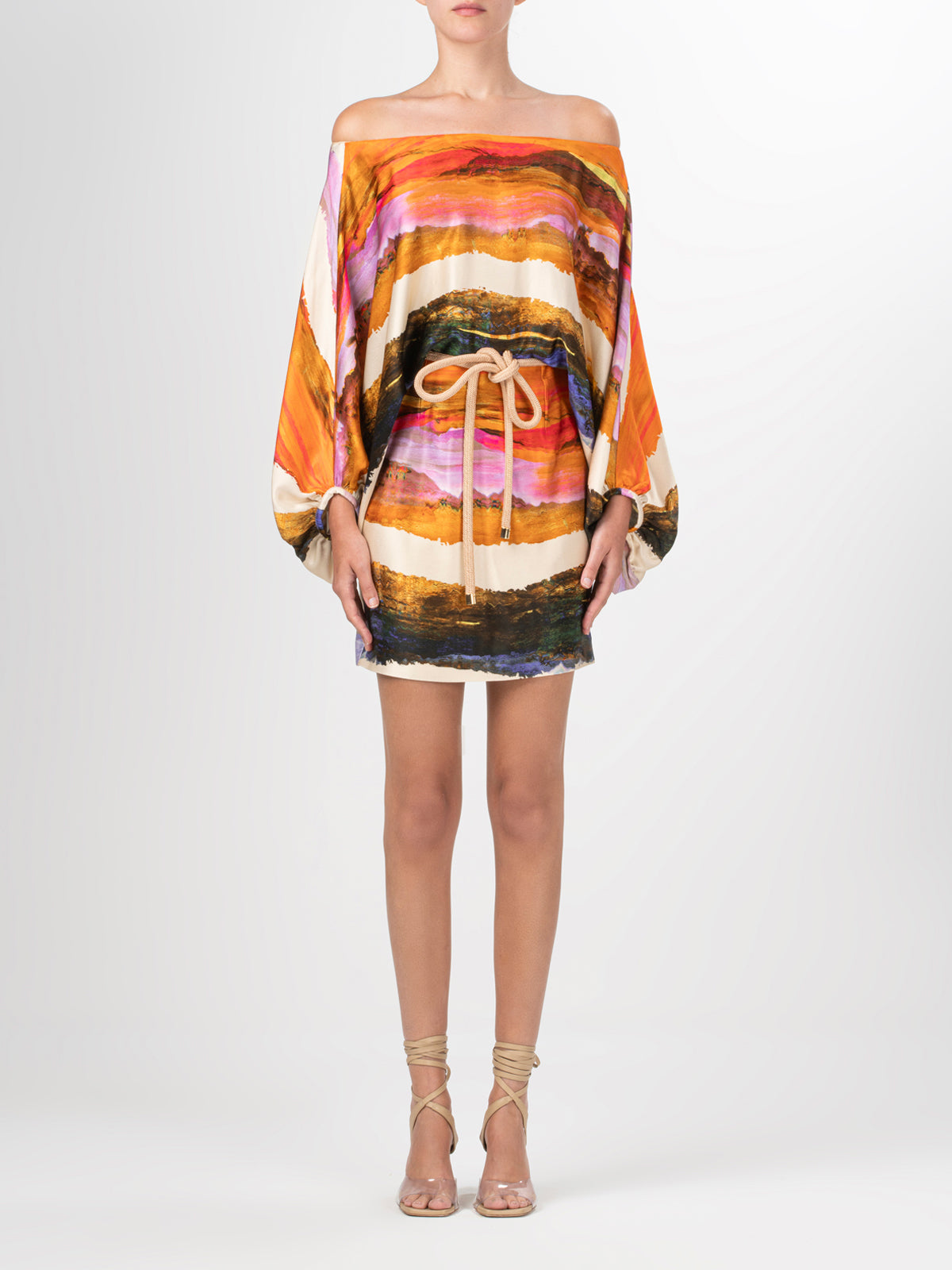 An off-the-shoulder Manon Dress Orange Orchid Abstract Stripes with an abstract painting.