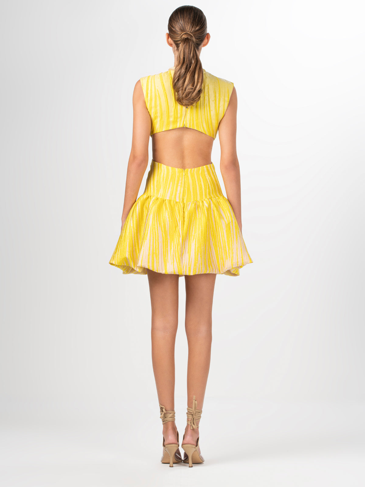 A yellow Nadra Dress Yellow Pink Ripple with a ruffled skirt.