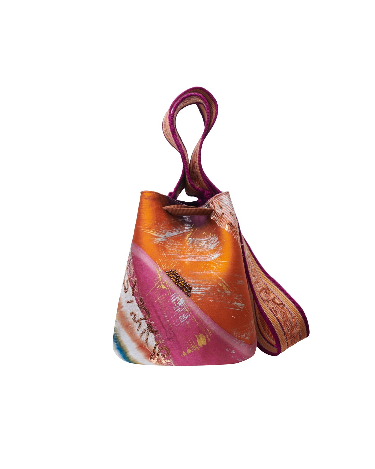 La Mochila Laaput Trinitaria es un bolso colorido y estructurado con tonos abstractos de naranja, rosa y blanco. Inspirada en el arte tradicional Wayuu, presenta una correa ancha con textura y una forma cilíndrica para lograr un estilo artístico y elegante que recuerda a una mochila.